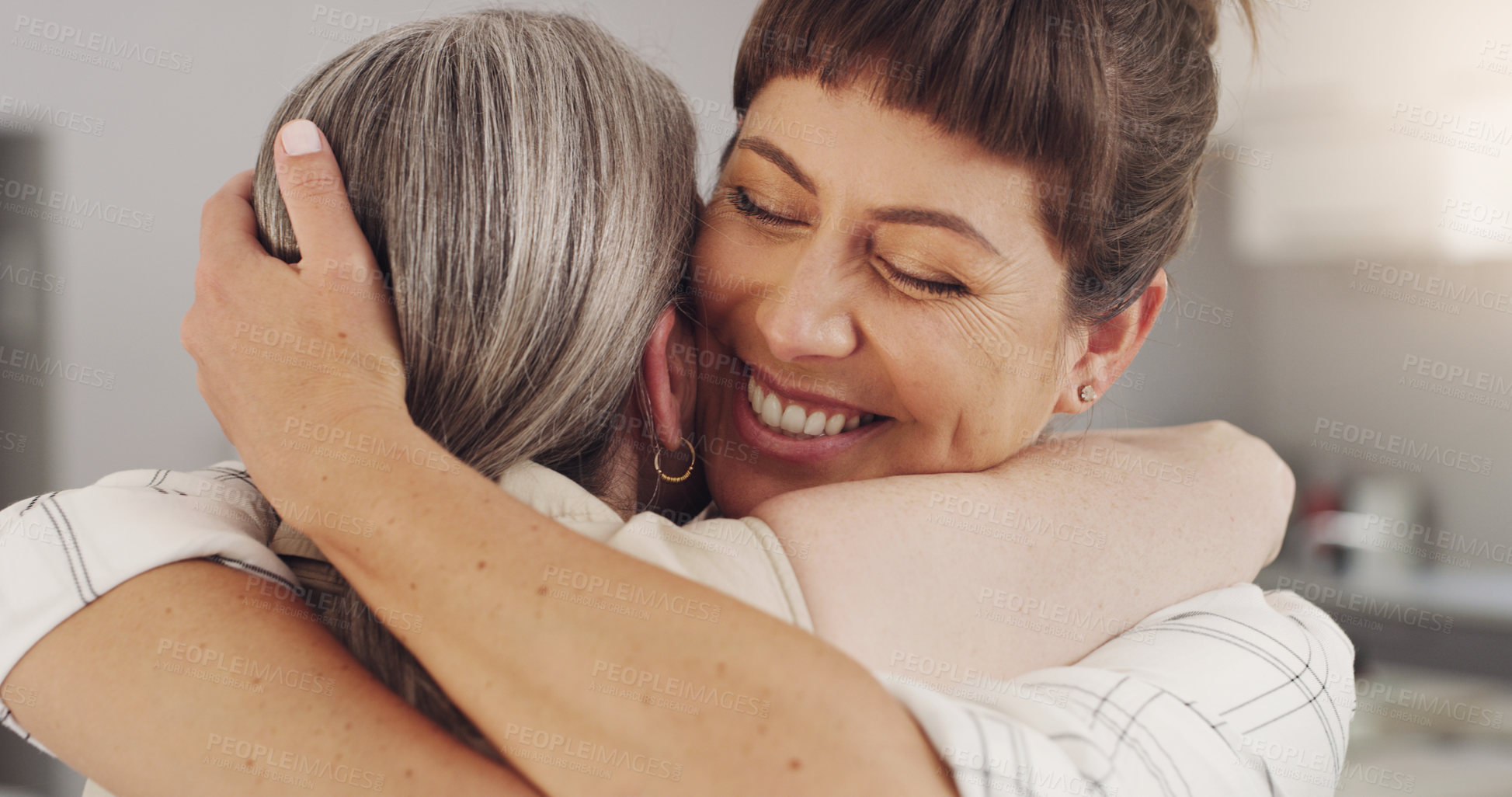 Buy stock photo Shot of a mother and daughter embracing at home