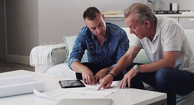 Buy stock photo Shot of a father and son duo going over blueprints at home