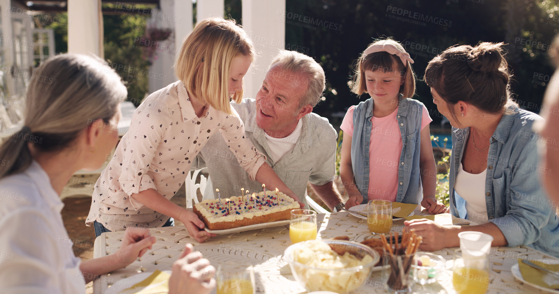 Buy stock photo Family, birthday or outdoor celebration with cake for love, bonding and conversation on weekend break. Happy, people and food with drinks in garden for relax talk or morning dessert together