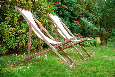 Buy stock photo Two garden chairs on a lawn for a relaxing and quiet view of nature outside. Decorating and landscaping a park or natural environment with seats on grass. Lush plants in a peaceful backyard 