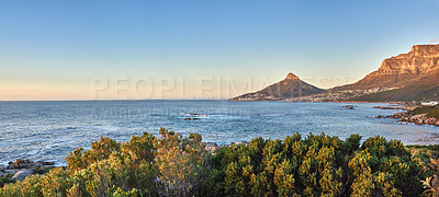 Buy stock photo Stunning blue ocean with mountains on sunrise sky background and copy space. Summer landscape of the sea shore with a view of Lions Head and Table Mountain attraction in Cape Town, South Africa