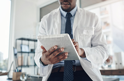 Buy stock photo Shot of an unrecognizable doctor using a digital tablet in an office