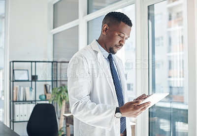 Buy stock photo Medical, black man and doctor with tablet, serious and telehealth in clinic, online and working in office. Healthcare, hospital and internet, technology and science for research, web and staff