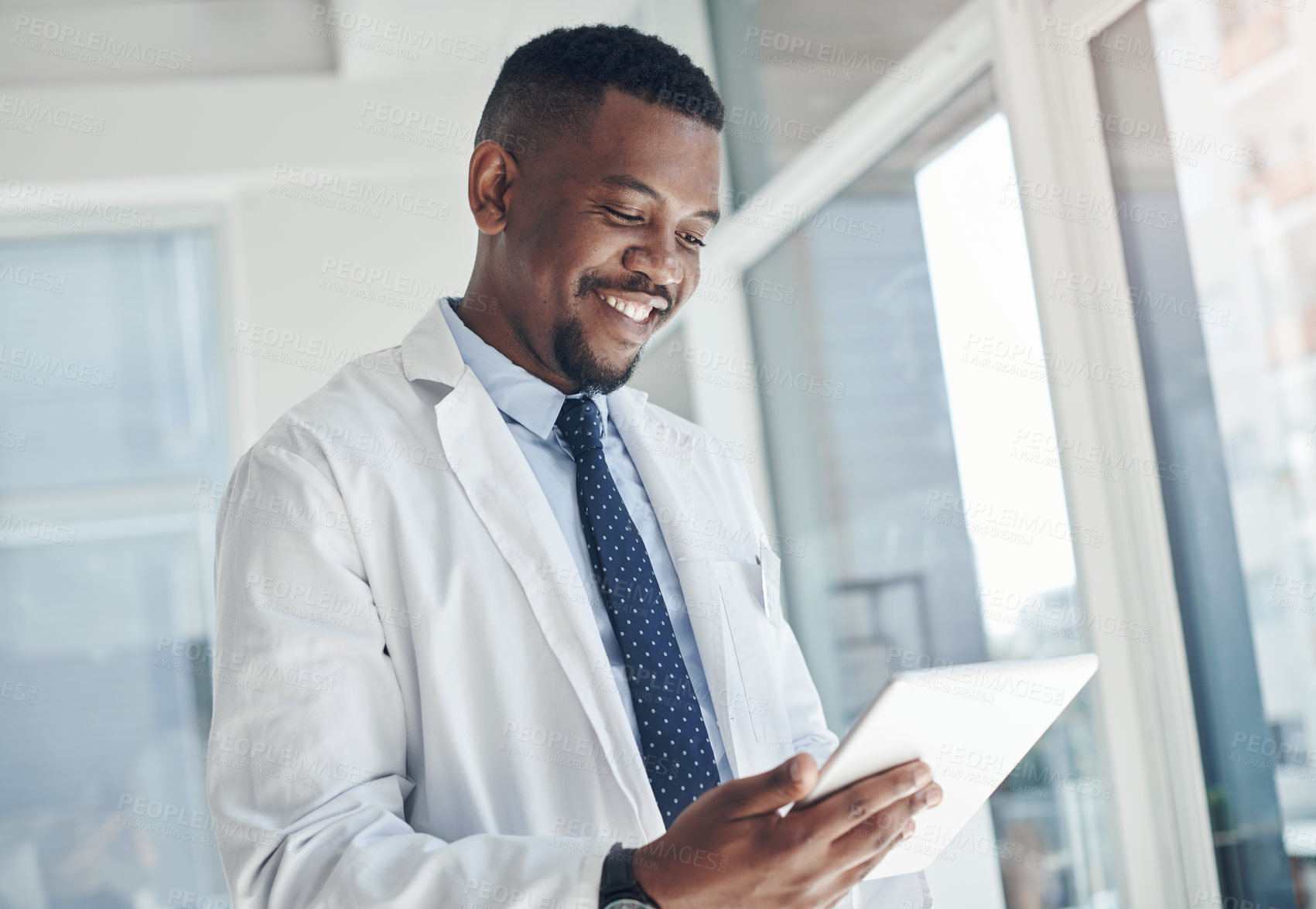 Buy stock photo Shot of a young doctor using a digital tablet in an office