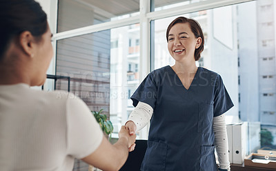 Buy stock photo Shot of a young female doctor shaking hands with a patient in an office