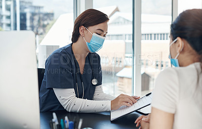 Buy stock photo Shot of a young female doctor writing down a patient's information in an office