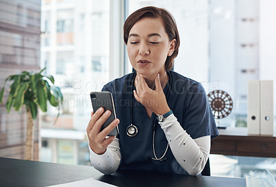 Buy stock photo Shot of a young doctor using a cellphone in an office