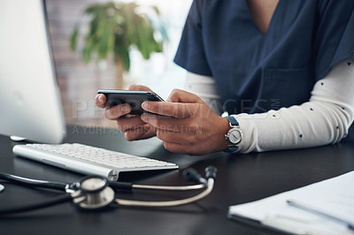 Buy stock photo Shot of an unrecognizable doctor using a cellphone in an office