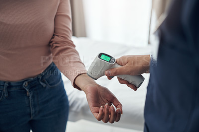 Buy stock photo Shot of an unrecognizable doctor using a thermometer to take a patient's temperature in an office