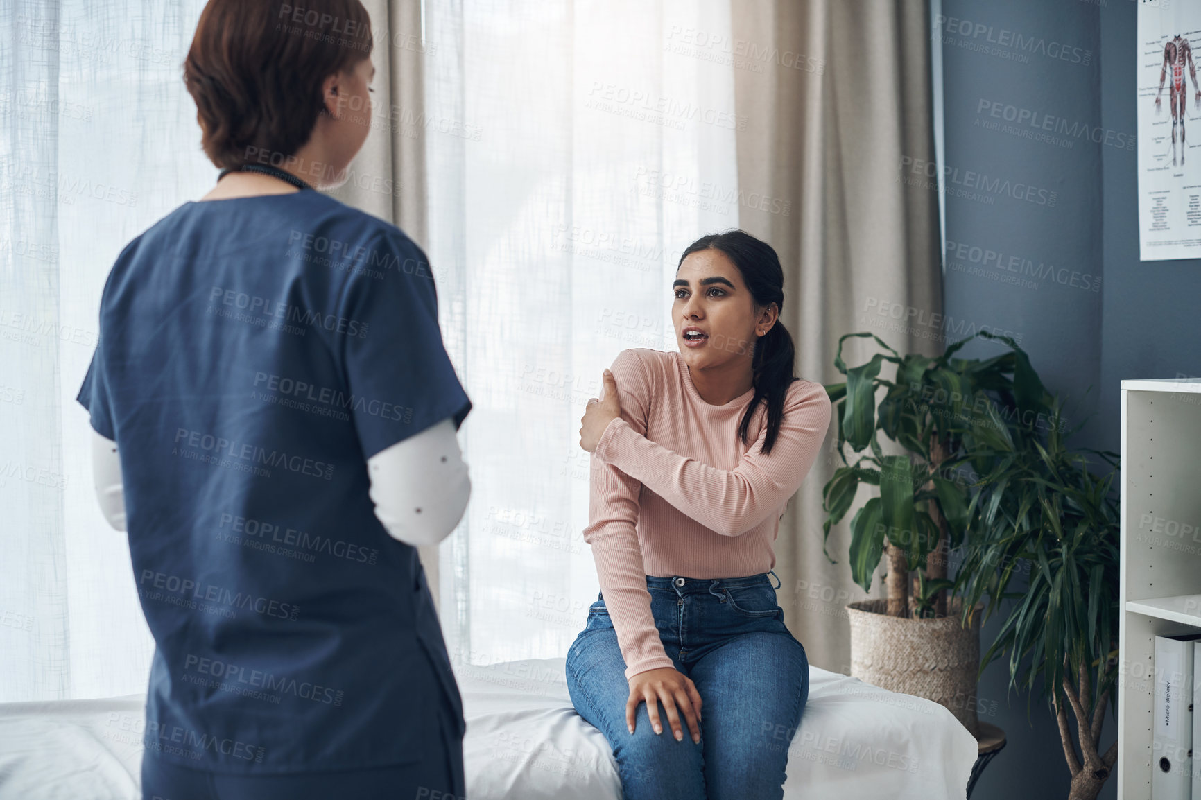 Buy stock photo Shot of a young female patient talking to a doctor in an office