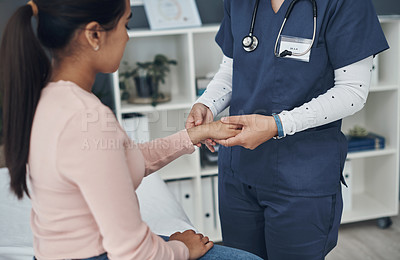 Buy stock photo Shot of a unrecognizable doctor checking a patient's wrist in an office