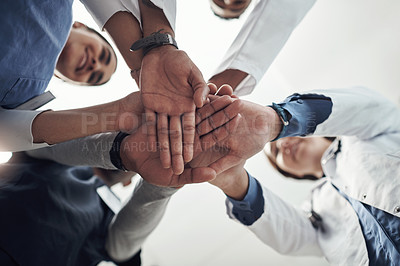 Buy stock photo Shot of a group of young doctors and n nurses with their hands stacked
