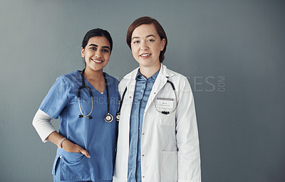 Buy stock photo Shot of two young health workers in a hospital in front of grey background