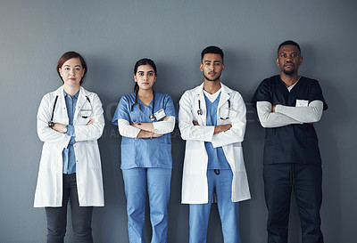 Buy stock photo Shot of a group of doctors standing against a grey background at work