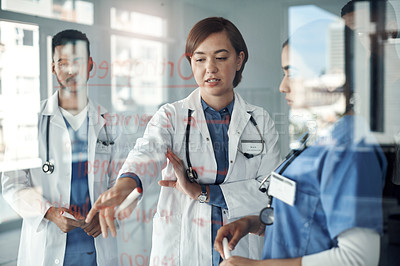 Buy stock photo Shot a group of doctors discussing formulas in the office at work