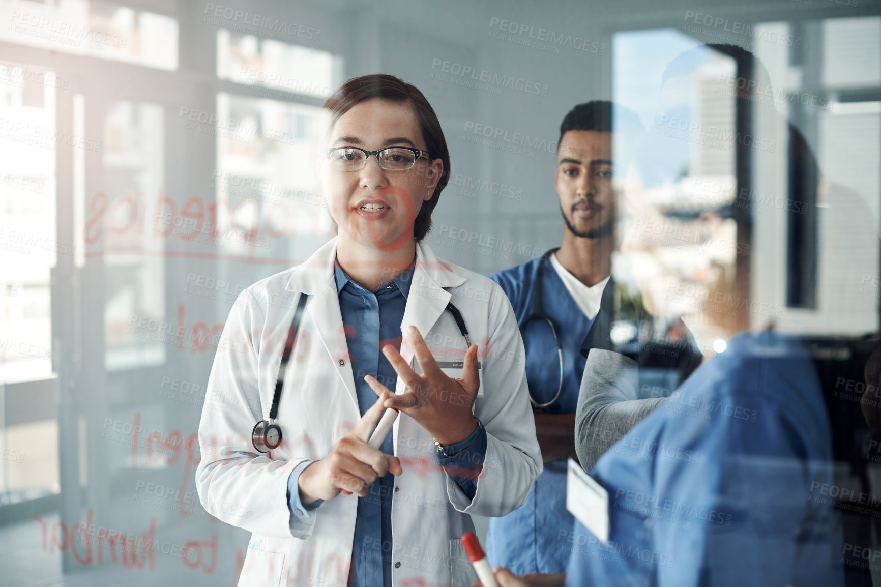 Buy stock photo Shot a group of doctors discussing formulas in the office at work