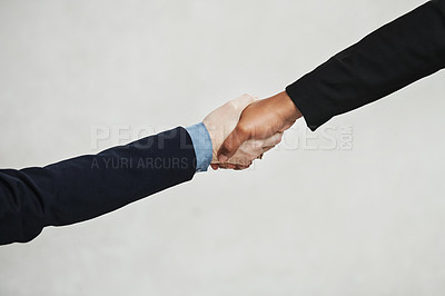 Buy stock photo High angle shot of two unrecognisable businesswomen shaking hands in a modern office