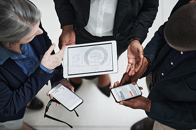 Buy stock photo Shot of a group of businesspeople using wireless devices during a meeting in a modern office