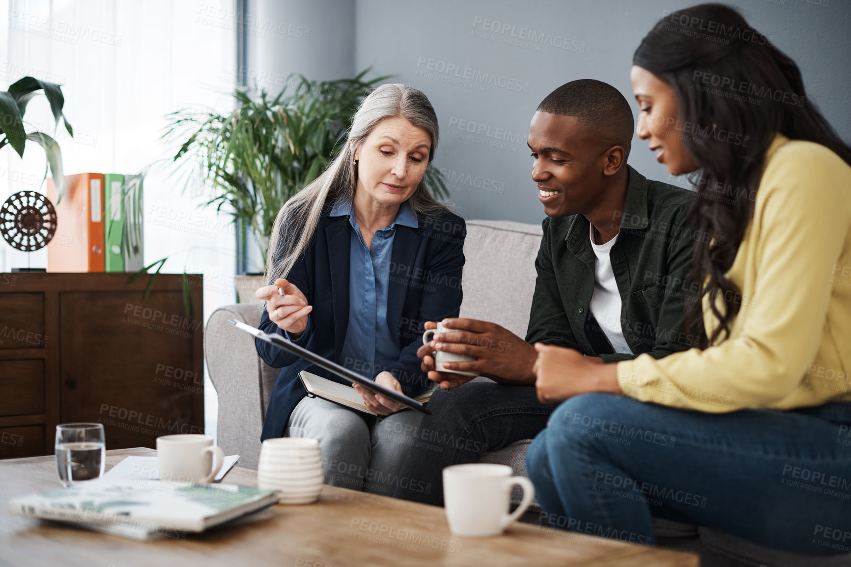 Buy stock photo Shot of a couple speaking to a financial advisor at home