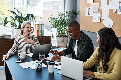 Buy stock photo Shot of a group of businesspeople brainstorming and using a laptop in a modern office