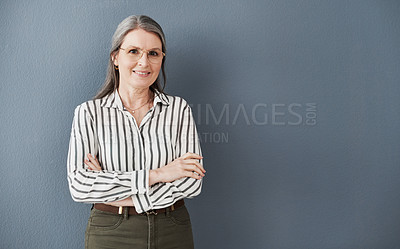 Buy stock photo Shot of a mature businesswoman posing with arms crossed against a black background