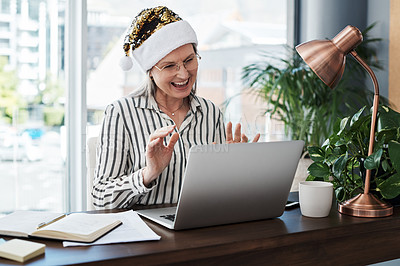 Buy stock photo Shot of a mature businesswoman using her laptop for a video call in a modern office