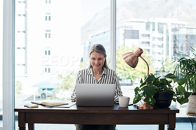 Buy stock photo Shot of a mature businesswoman using her laptop in a modern office