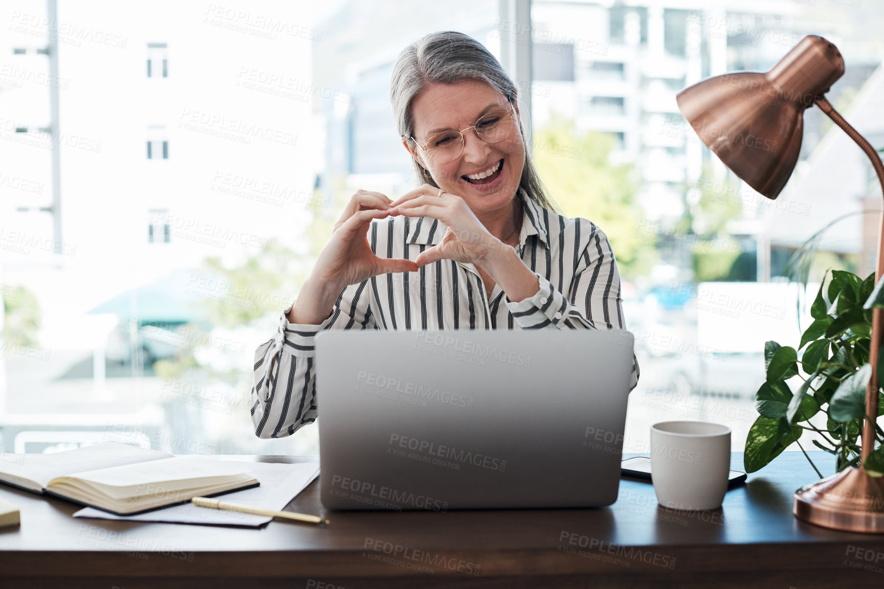 Buy stock photo Laptop, heart sign and mature woman in office for virtual meeting, communication or networking. Business, brand manager and female employee with love hand gesture for conference, online or support