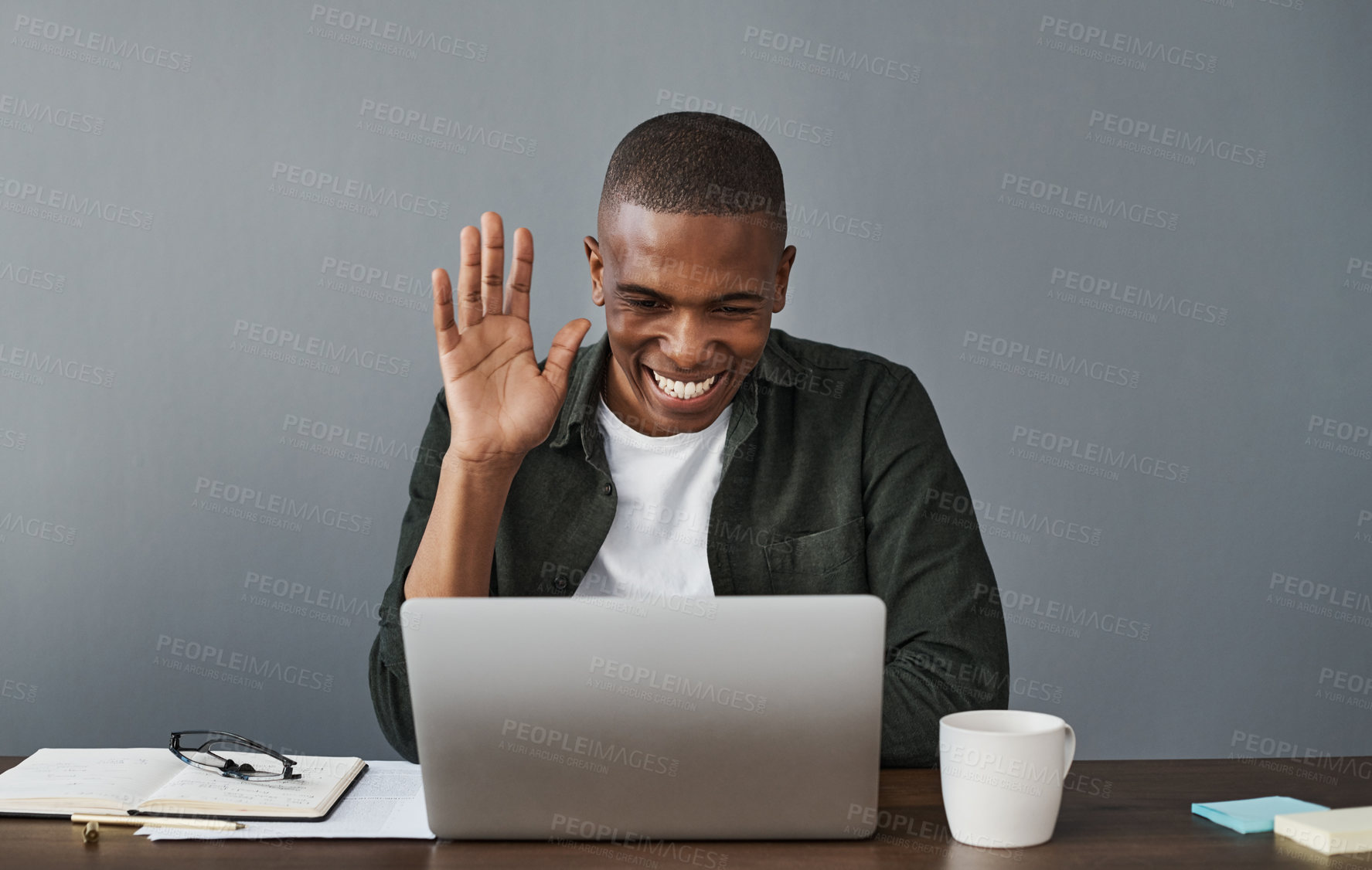 Buy stock photo Shot of a young businessman working from home and using his laptop to make a video call