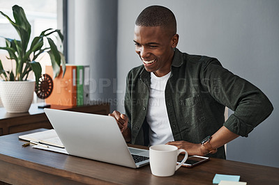 Buy stock photo Shot of a young businessman using his laptop while working from home