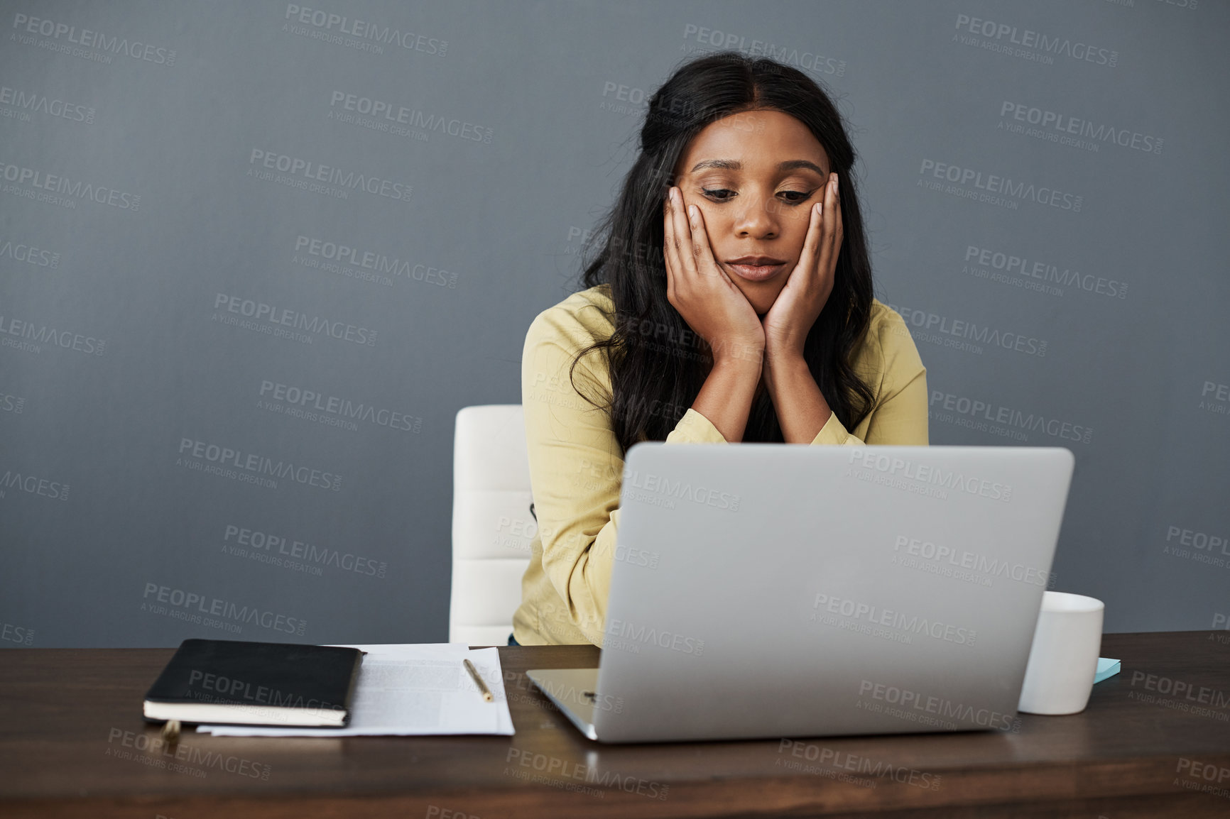 Buy stock photo Shot of a young businesswoman looking bored at her desk