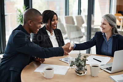 Buy stock photo Shot of a mature businesswoman shaking hands with a colleague in a modern office