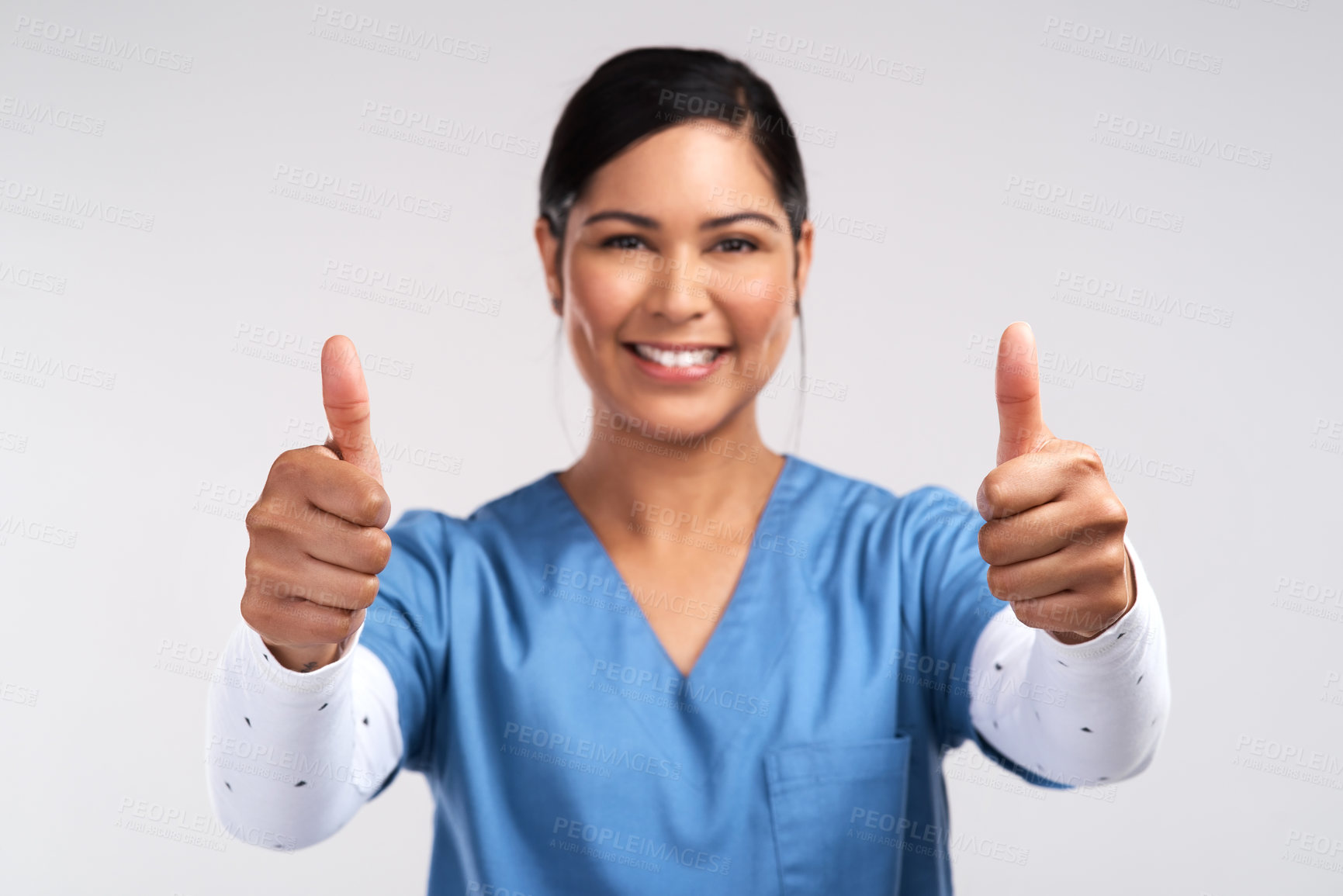 Buy stock photo Portrait of a young doctor showing a thumbs up sign against a white background