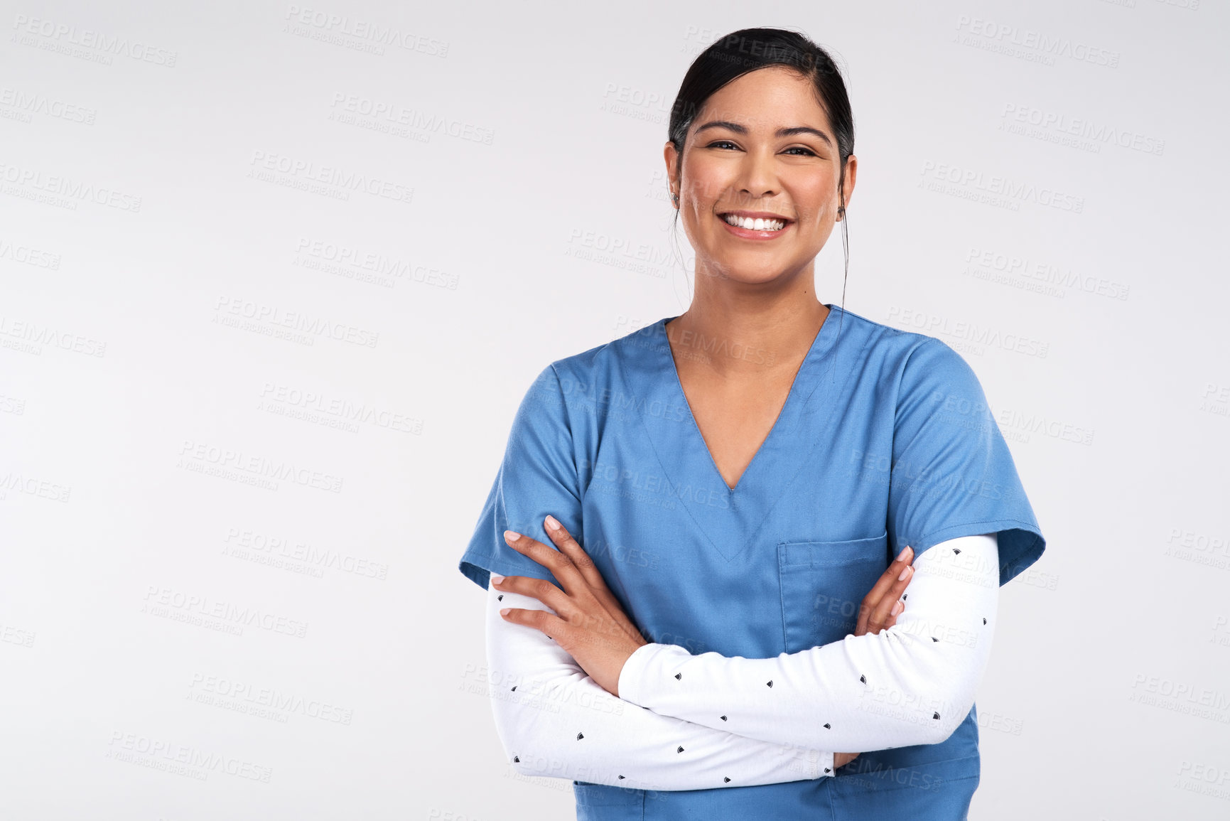 Buy stock photo Portrait of a beautiful young doctor standing with arms folded against a white background