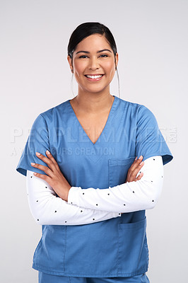 Buy stock photo Portrait of a beautiful young doctor standing with arms folded against a white background