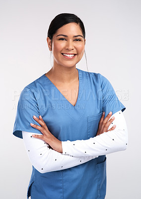Buy stock photo Portrait of a beautiful young doctor standing with arms folded against a white background