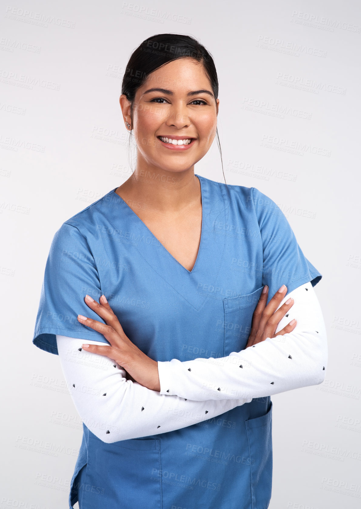 Buy stock photo Portrait of a beautiful young doctor standing with arms folded against a white background