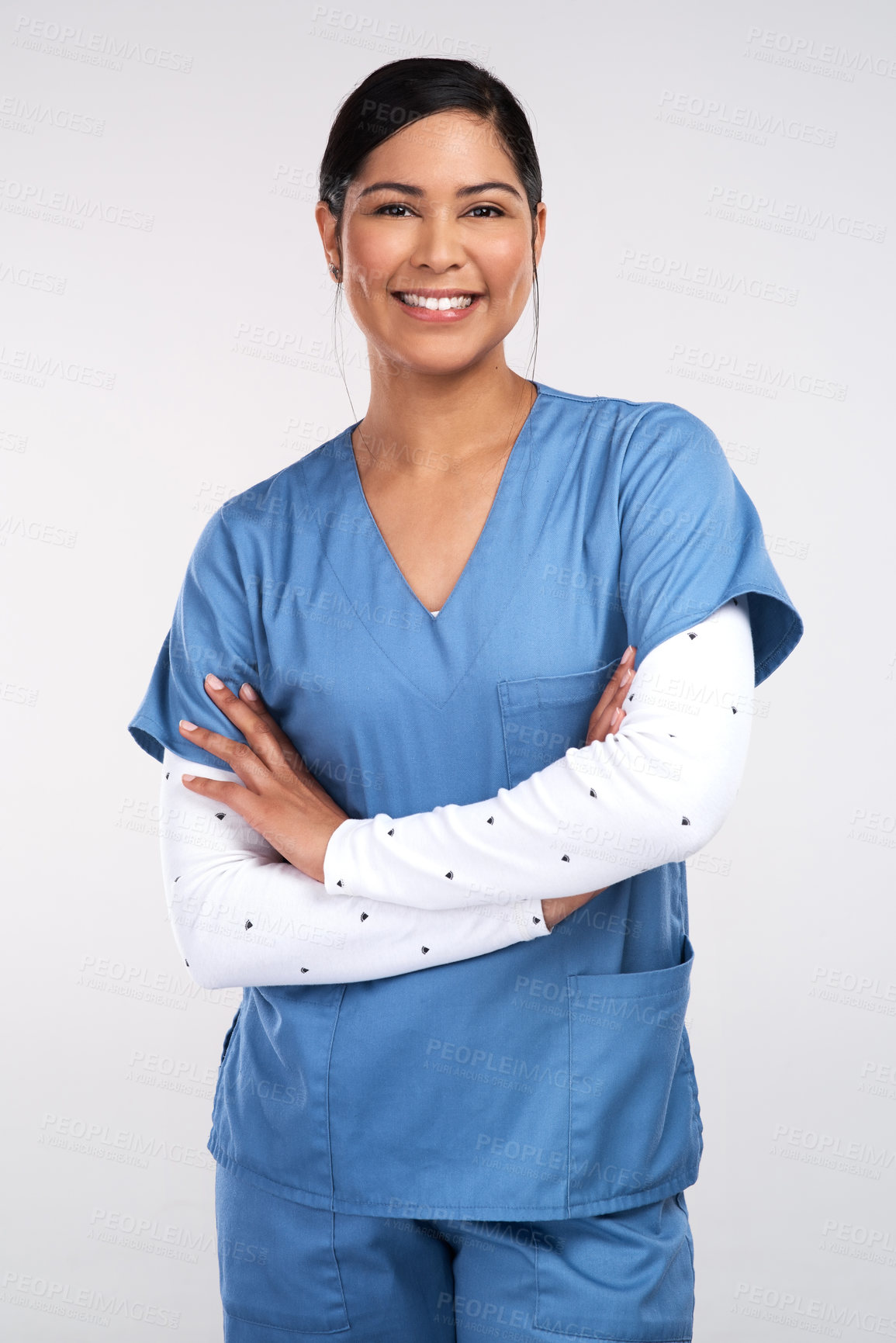 Buy stock photo Portrait of a beautiful young doctor standing with arms folded against a white background