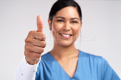 Buy stock photo Portrait of a young doctor showing a thumbs up sign against a white background