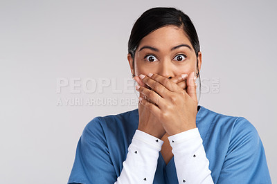 Buy stock photo Portrait of a shocked young doctor covering her mouth in scrubs against a white background