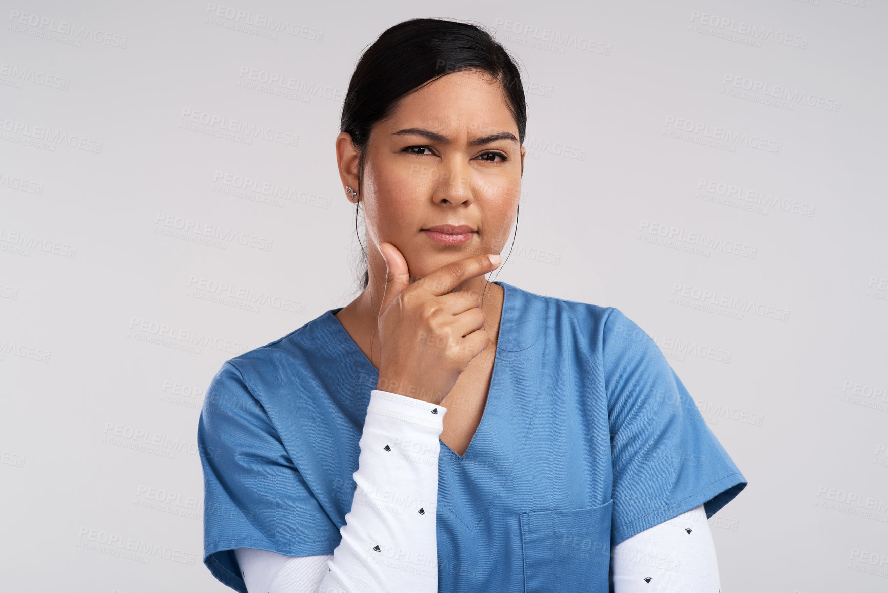 Buy stock photo Portrait of a young beautiful doctor deep in thought against a white background