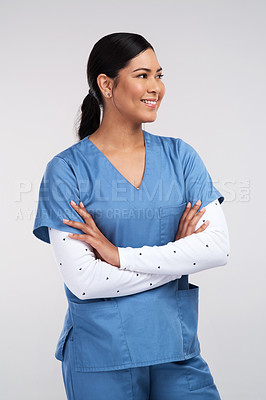 Buy stock photo Shot of a beautiful young doctor standing with arms folded against a white background