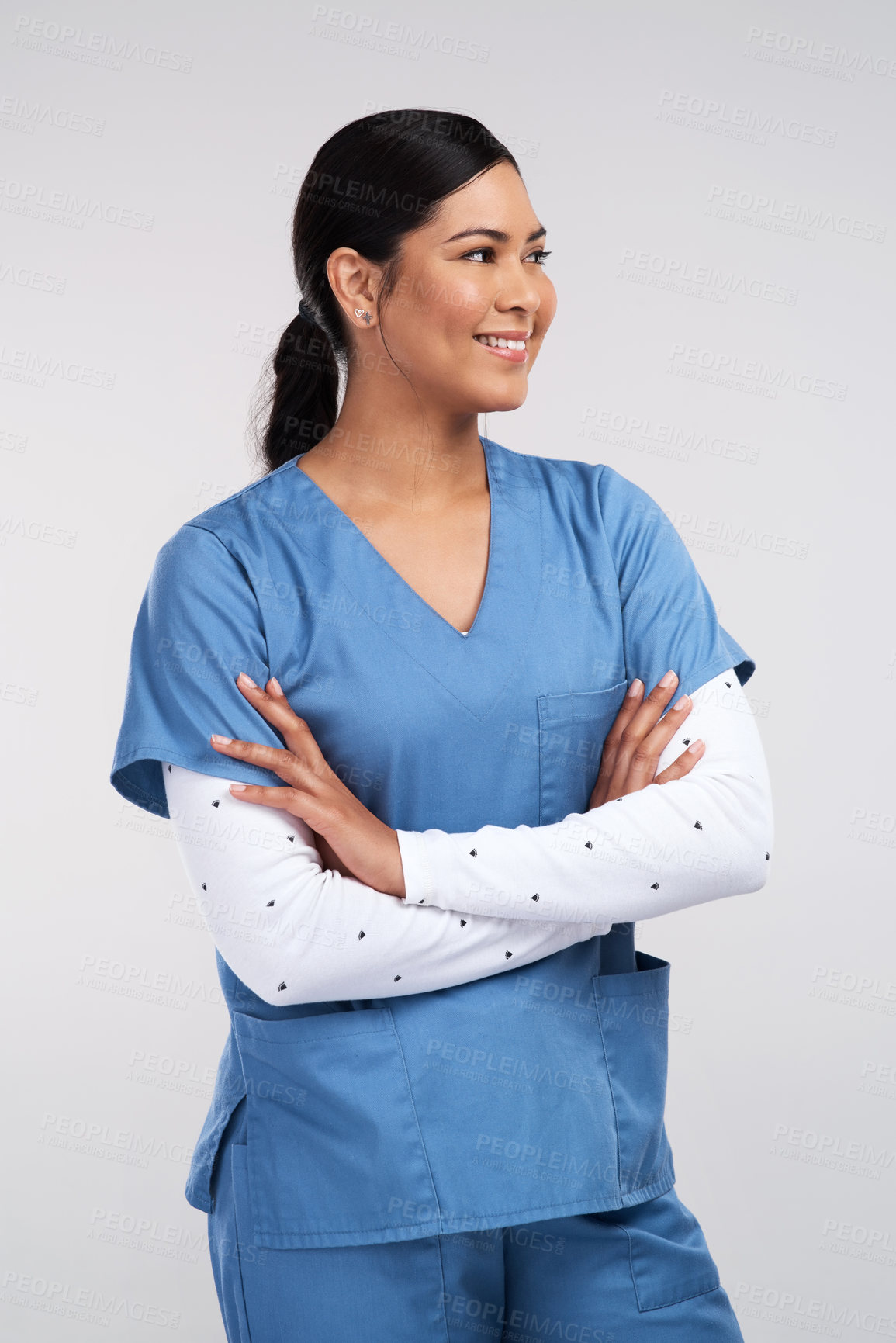 Buy stock photo Shot of a beautiful young doctor standing with arms folded against a white background