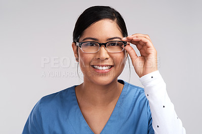 Buy stock photo Portrait of a young doctor wearing glasses and scrubs against a white background