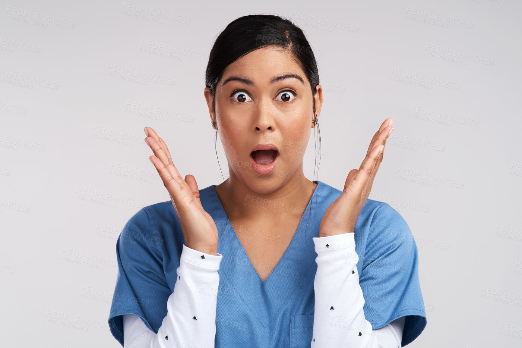 Buy stock photo Portrait of a shocked young doctor in scrubs against a white background