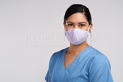 Buy stock photo Portrait of a young doctor wearing a face mask against a white background