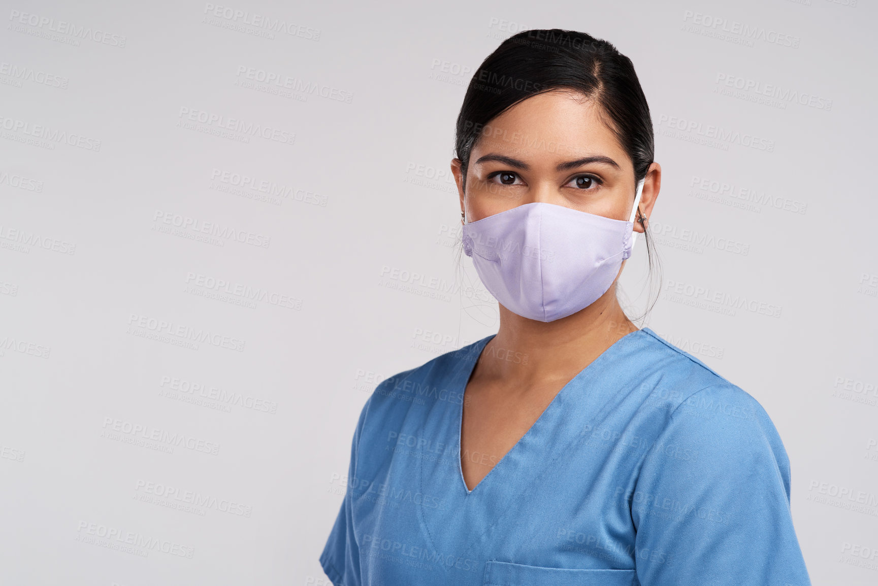 Buy stock photo Portrait of a young doctor wearing a face mask against a white background