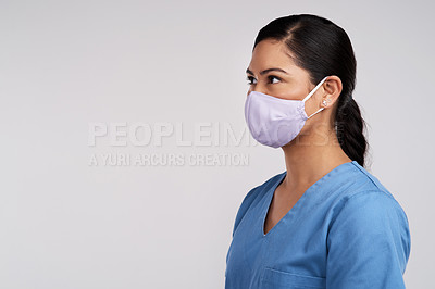 Buy stock photo Side shot of a young doctor wearing a surgical face mask against a white background