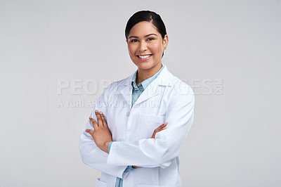 Buy stock photo Cropped portrait of an attractive young female scientist standing with her arms folded in studio against a grey background