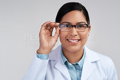 Buy stock photo Cropped portrait of an attractive young female scientist wearing glasses in studio against a grey background